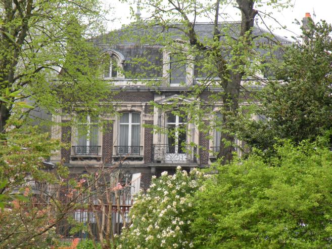  immeuble en briques, caché par la verdure